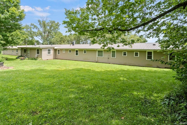 rear view of house featuring a lawn