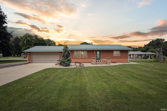 ranch-style house with a garage and a yard