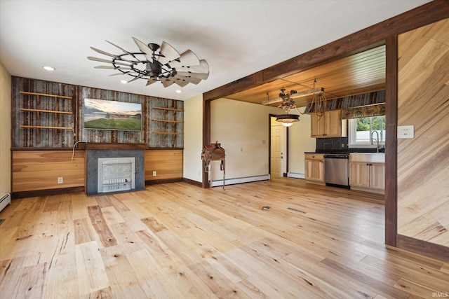 unfurnished living room with sink, light wood-type flooring, ceiling fan, and a baseboard heating unit