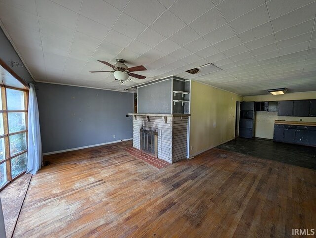 unfurnished living room with a brick fireplace, ceiling fan, and hardwood / wood-style floors