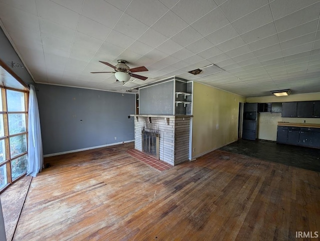 unfurnished living room with hardwood / wood-style floors, a fireplace, a ceiling fan, and baseboards