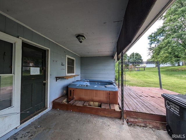 deck with a hot tub and a yard