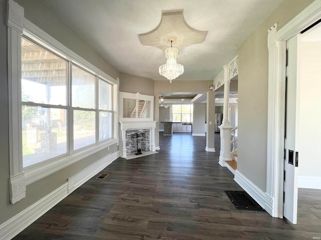 hall featuring a textured ceiling, a chandelier, and dark wood-type flooring