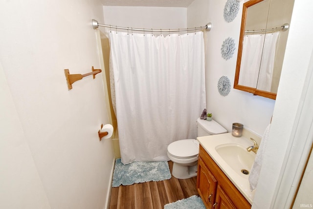 bathroom featuring toilet, walk in shower, hardwood / wood-style flooring, and vanity