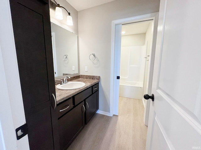 bathroom featuring vanity, bathing tub / shower combination, and hardwood / wood-style floors