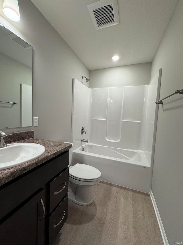 full bathroom with wood-type flooring, toilet, bathing tub / shower combination, and vanity