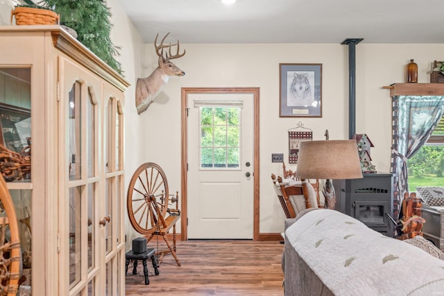 interior space with a wood stove and hardwood / wood-style flooring