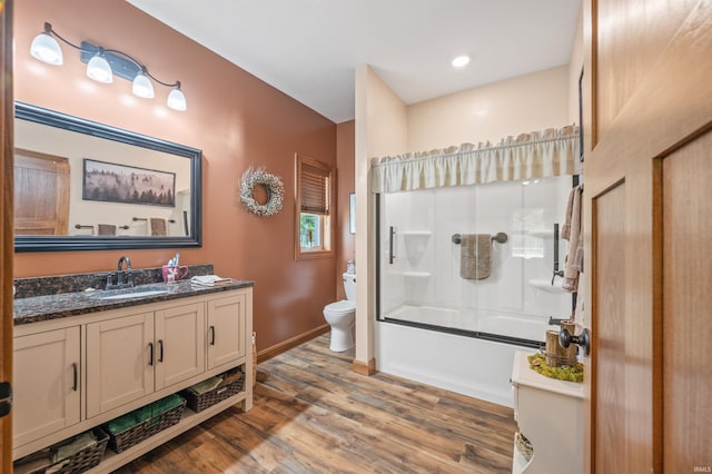 full bathroom with vanity, shower / bath combination with glass door, toilet, and hardwood / wood-style floors