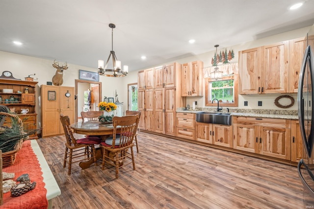 dining room featuring a notable chandelier, sink, and wood-type flooring