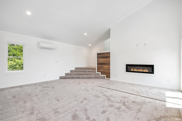 unfurnished living room with a wall unit AC, carpet flooring, and high vaulted ceiling