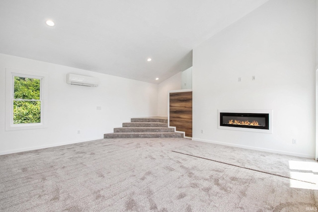 unfurnished living room with high vaulted ceiling, an AC wall unit, and carpet