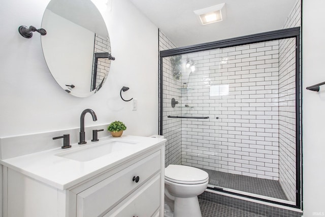 bathroom with vanity, an enclosed shower, and toilet