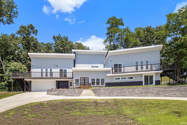 view of front of property with a garage, a wooden deck, french doors, and a front lawn