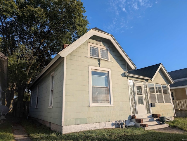 view of front facade featuring a sunroom, entry steps, and crawl space