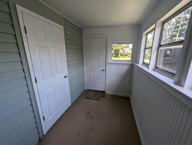 interior space featuring concrete floors and wooden walls