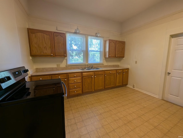 kitchen with light countertops, brown cabinets, stainless steel electric stove, light floors, and a sink