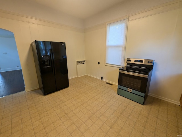 kitchen with baseboards, black refrigerator with ice dispenser, visible vents, arched walkways, and electric stove