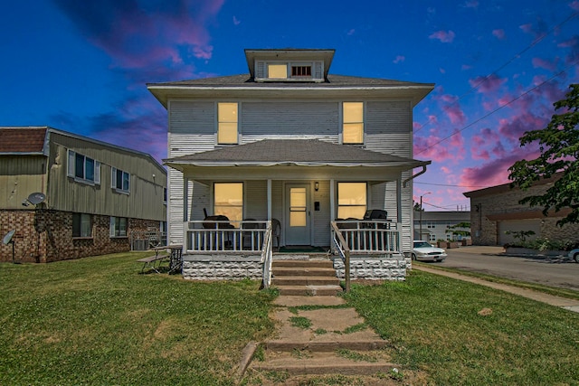 view of front of property featuring covered porch, central air condition unit, a garage, and a lawn