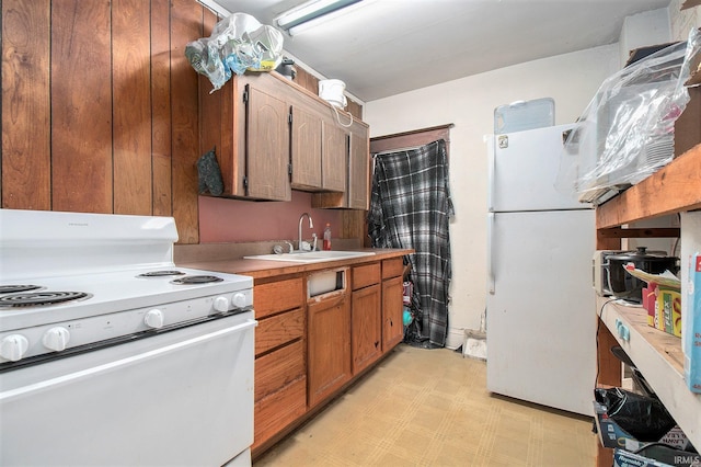 kitchen with sink, white appliances, and light tile patterned floors