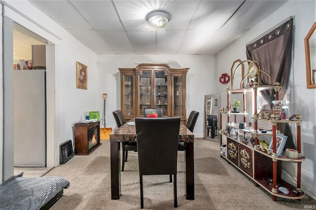 dining room with a drop ceiling and carpet floors