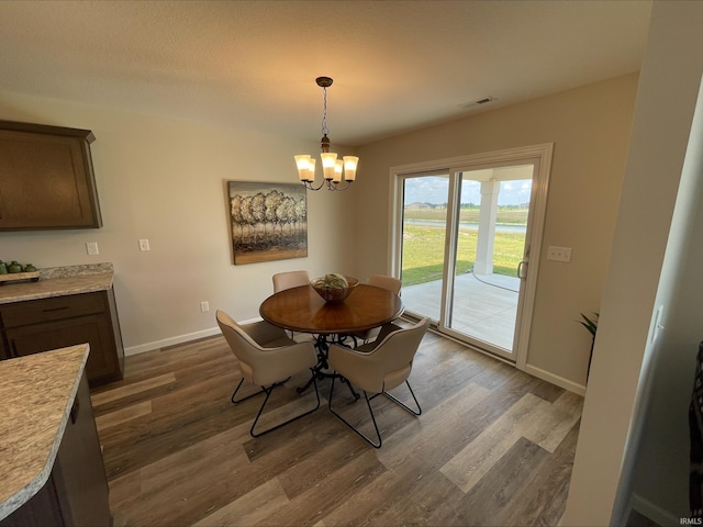 dining space with a notable chandelier and dark wood-type flooring