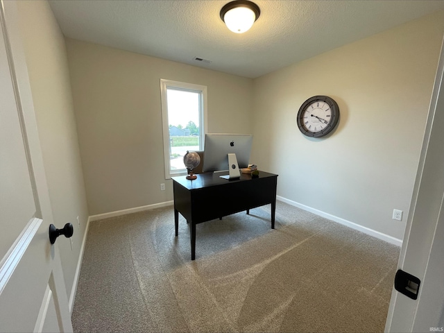 carpeted office space featuring a textured ceiling