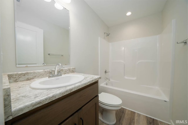 full bathroom featuring vanity, wood-type flooring, toilet, and washtub / shower combination