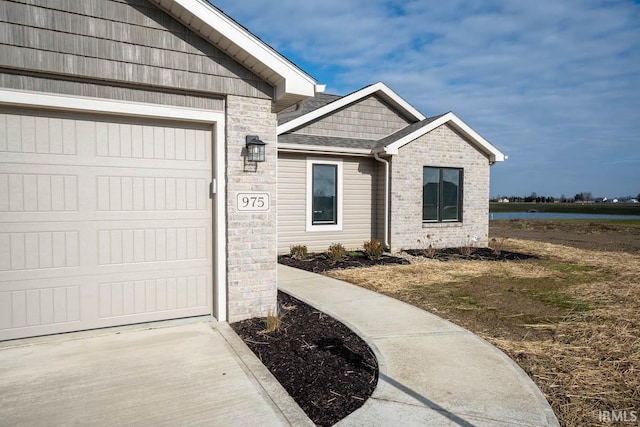 doorway to property with a garage and a water view