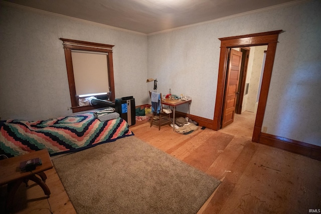 bedroom with light hardwood / wood-style floors and crown molding