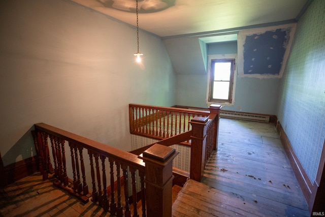 stairs featuring a baseboard radiator, hardwood / wood-style flooring, and lofted ceiling