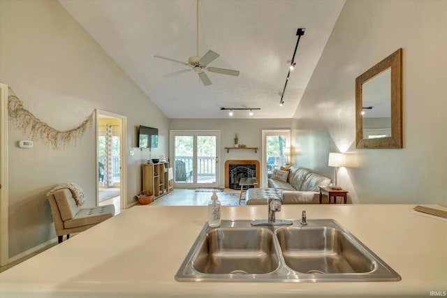 kitchen with ceiling fan, sink, track lighting, and vaulted ceiling