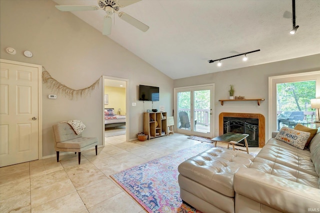 tiled living room featuring ceiling fan, rail lighting, plenty of natural light, and high vaulted ceiling