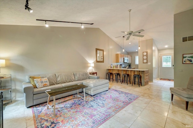 living room featuring ceiling fan, high vaulted ceiling, a textured ceiling, and rail lighting