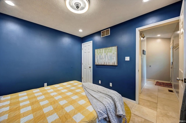 tiled bedroom featuring a textured ceiling