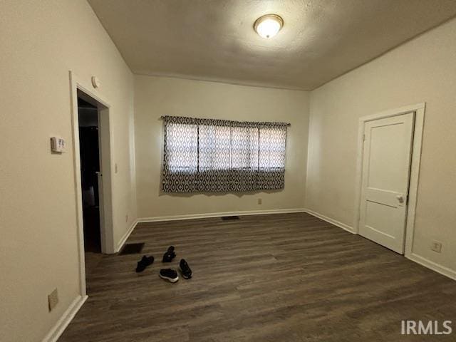 empty room with dark wood-type flooring