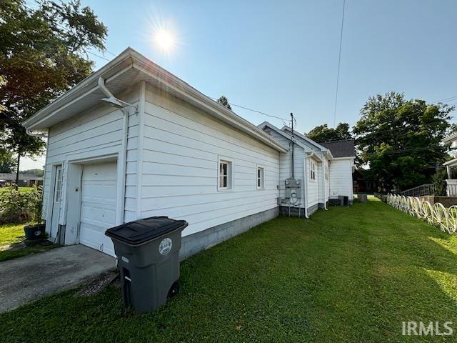 view of side of home with a garage and a yard