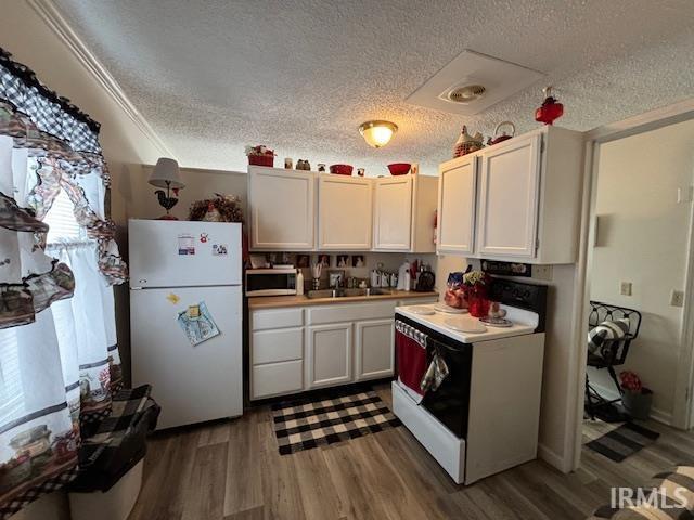 kitchen featuring dark wood-type flooring, sink, white cabinetry, a textured ceiling, and white appliances