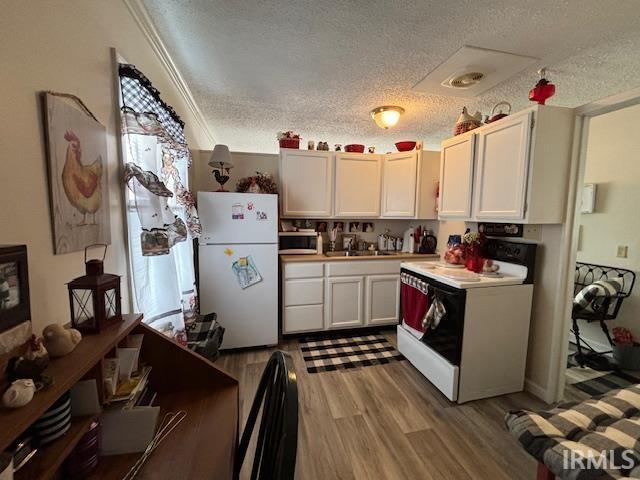 kitchen with sink, white appliances, a textured ceiling, and white cabinets