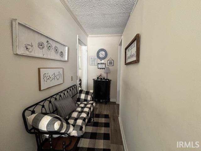 corridor featuring hardwood / wood-style flooring, crown molding, and a textured ceiling