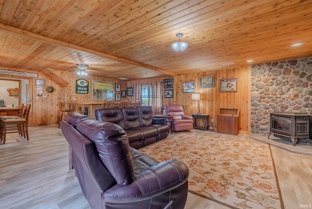 living room featuring wood ceiling, wood walls, light hardwood / wood-style floors, and a wood stove