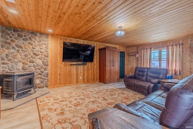 living room with hardwood / wood-style floors, wooden walls, wooden ceiling, and a wood stove