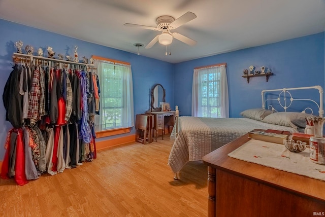 bedroom with a closet, ceiling fan, and light hardwood / wood-style flooring