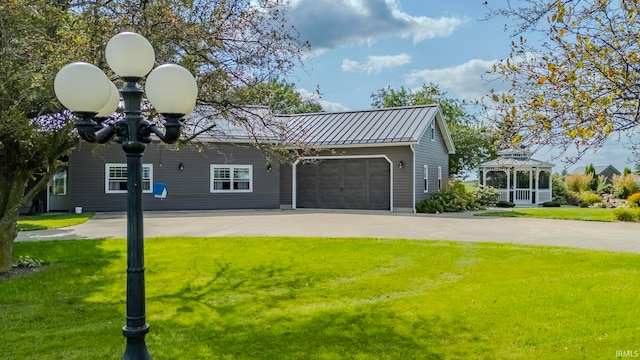 view of front facade with a garage, a gazebo, and a front lawn