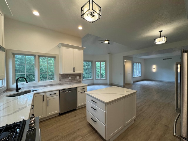 kitchen featuring ceiling fan, hardwood / wood-style flooring, stainless steel appliances, pendant lighting, and sink