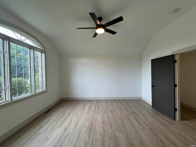 spare room with light hardwood / wood-style flooring, lofted ceiling, and ceiling fan