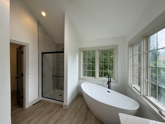 bathroom featuring shower with separate bathtub, lofted ceiling, and hardwood / wood-style floors