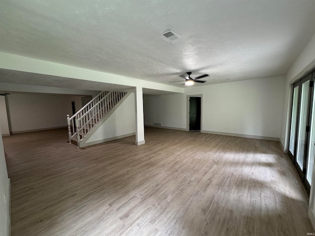 unfurnished living room featuring hardwood / wood-style flooring, a textured ceiling, and ceiling fan