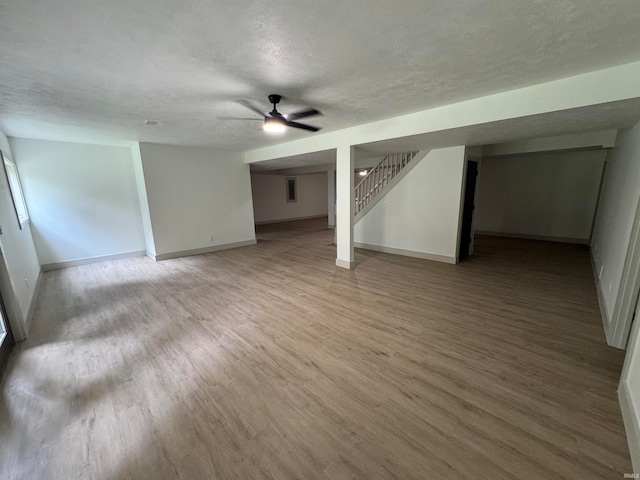 interior space with wood-type flooring, a textured ceiling, and ceiling fan