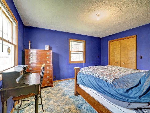 carpeted bedroom with a textured ceiling and a closet