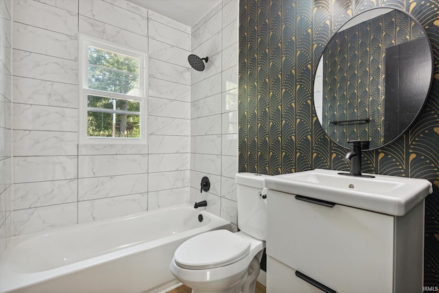 full bathroom featuring vanity, tiled shower / bath, and toilet